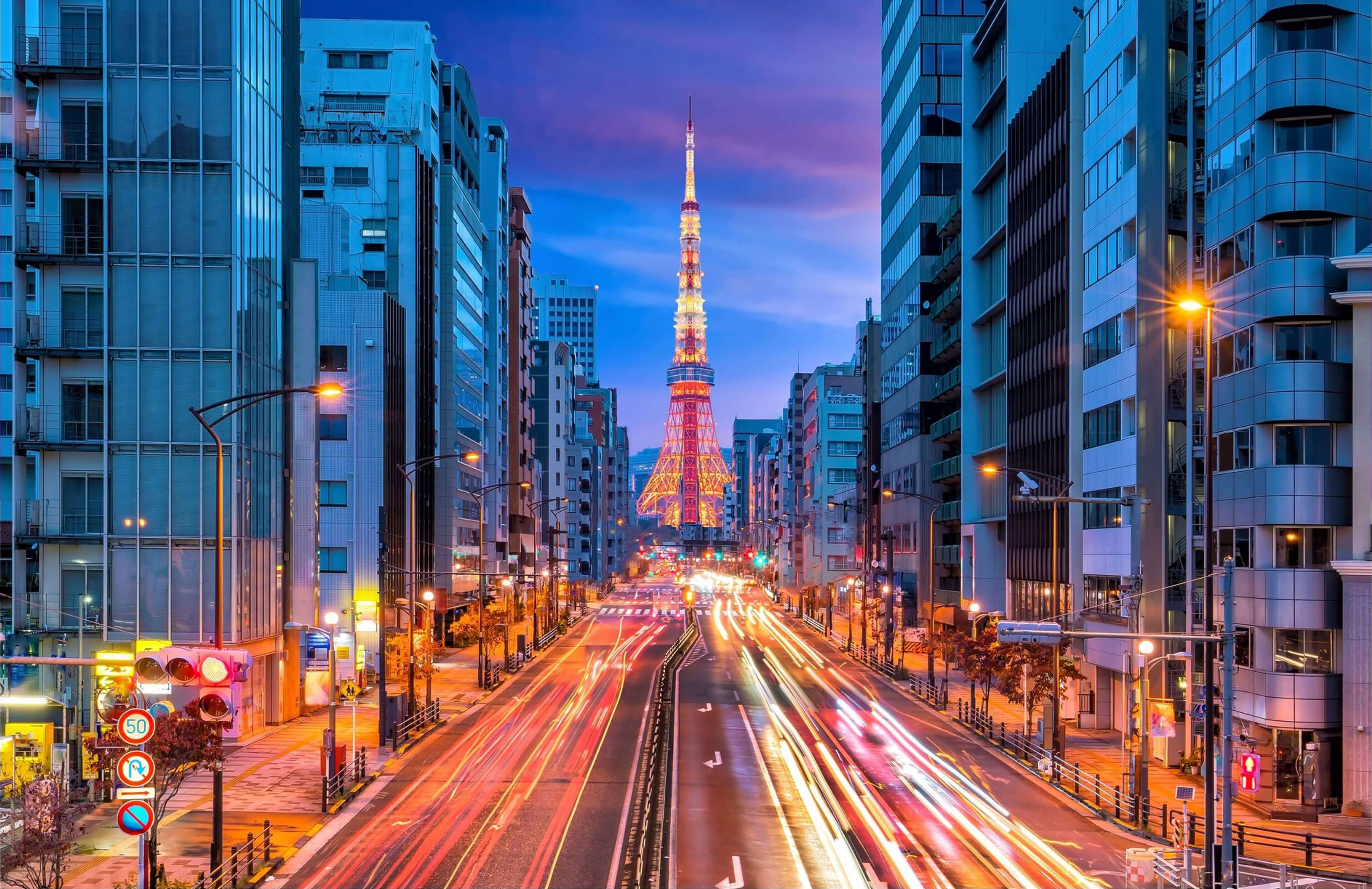 Panoramic city photo at night with a tower in the background